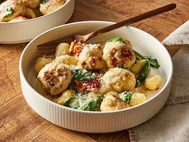 Kremalı sos ve ıspanak ile servis edilen köfte ve gnocchi yemeği.